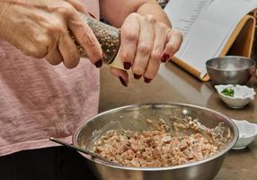 Chef peppers dish with salmon in bowl photo