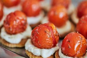 Appetizers with ricotta cheese and cherry tomatoes on serving tray
