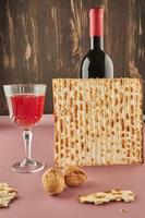 Pesah celebration concept - jewish Passover holiday. Matzo, bottle of wine with glass and nuts