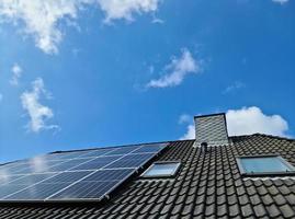 Solar panels producing clean energy on a roof of a residential house photo