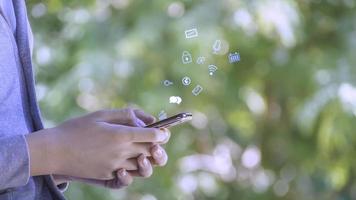 The boy wearing glasses using smart phone with Social media with icons,  living on vacation and playing social media concept Businessman using phone ,Social, media, Marketing with functional icons. photo