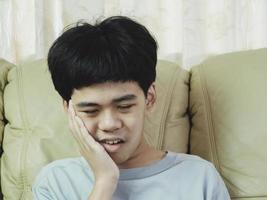 el niño pequeño de asia sufre de dolor de muelas. él triste con dolor de dientes, enfermedad dental, niño que sufre de problemas dentales. plan de cita con el dentista. foto