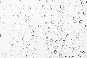 Raindrops on a glass, abstract white background. photo