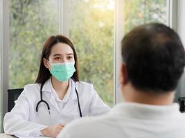 A female doctor is interviewing male patients at the healthcare center. A male patient came to the doctor at the hospital. photo