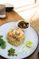 A view of a plate of shrimp fried rice in wood table on a restaurant . Top view. Delicious and easy menu. photo