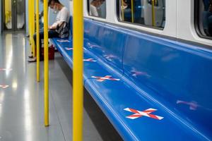 fila de asientos azules en el tren con cinta de marcado cruzada en el período coronavirus covid-19. significa distanciamiento social en el transporte. foto