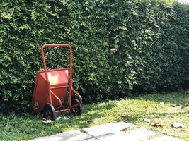red new Masonry cement cart trolley parking in the garden with tree background. Vintage style. photo