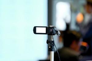 Grabador de video amateur y no profesional estático para grabar al orador en un pequeño seminario en la sala de conferencias. foto