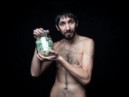 Young man with money bottle on black background photo