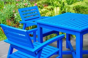 silla azul de madera y mesa en el jardín