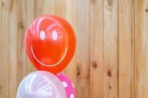 Smile red balloon in front of vertical wood plate background for any Happy card. photo
