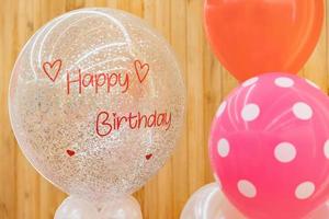 un texto de feliz cumpleaños en el globo para regalo en la fiesta de cumpleaños frente al fondo de madera. foto