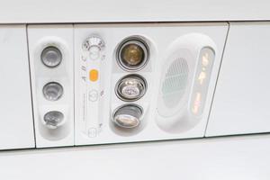 closeup airplane Console panel lamp, light, need help button, air condition, sefty belt and no smoking lighting sign. photo