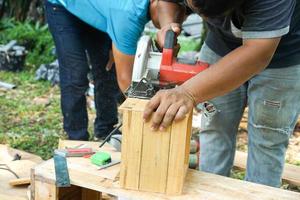 Asian carpenter are sawing the wood. photo