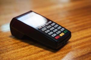 Payment terminal lying on a wooden table photo