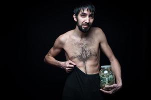 Young man with money bottle on black background photo