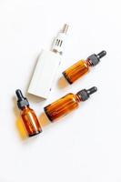 Vaping device e-cigarette electronic cigarette and liquid bottles isolated on white background. Vape device for alternative smoking. Vaping shop concept. Gadget for vaper. Vaping accessories. photo