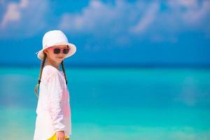 Adorable little girl at beach during summer vacation photo