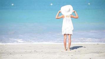 niña con sombrero en la playa durante las vacaciones en el caribe