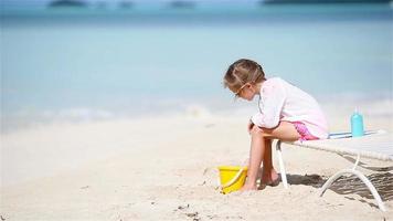 Adorable little girl playing with toys on beach vacation video