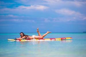 Beautiful surfer woman surfing during summer vacation photo