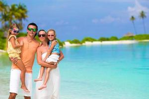 Happy family of four on beach vacation photo