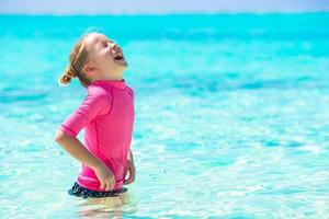 Adorable little girl at beach during summer vacation photo