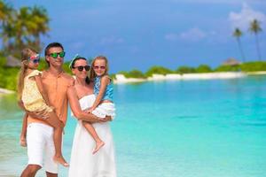 Happy family of four on beach vacation photo