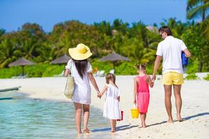 Young family on white beach during summer vacation photo