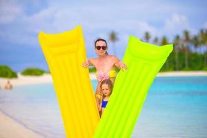 niña y madre feliz con colchón de aire en vacaciones de verano foto