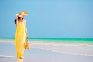 Young beautiful woman in big hat during tropical beach vacation photo