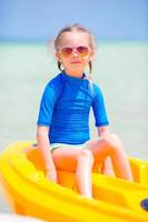 Adorable little girl kayaking during summer vacation photo
