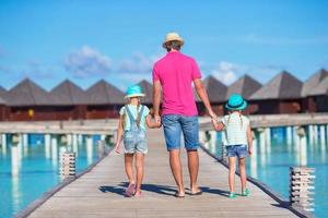 Father and little daughter on wooden jetty near water bungalow