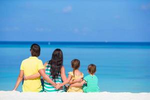 hermosa familia feliz en la playa blanca durante las vacaciones de verano foto