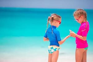 Adorable little girls at beach during summer vacation photo