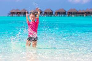 adorable niña divirtiéndose en la playa foto