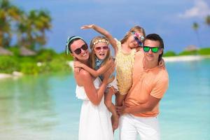 Happy beautiful family vacation on white beach photo