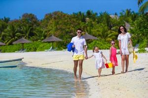 Happy family during summer vacation on white beach photo