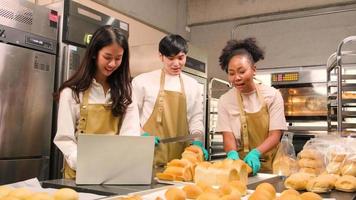 Three young friends and startup partners of bread dough and pastry foods busy with homemade baking jobs while cooking orders online, packing, and delivering on bakery shop, small business entrepreneur video