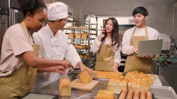 A chef's team staff who make bread dough and pastry foods are busy with homemade baking jobs while cooking orders online, packing, and delivering on bakery shop business, small business entrepreneur. video