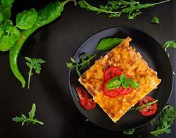 Classic Lasagna with bolognese sauce on dark background photo