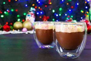taza de chocolate caliente con malvaviscos sobre fondo de navidad foto