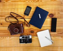 Flat lay, top view office table desk. Desk workspace with retro camera, diary, pen, case on wooden background. photo