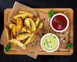 Baked potato with sauce and spices on dark background photo