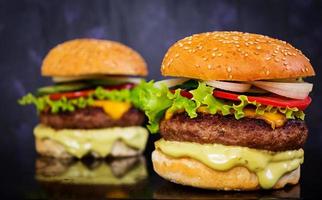 Delicious handmade burger on dark background. Close view photo