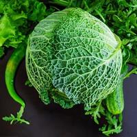 Savoy cabbage with pepper and greens on dark background