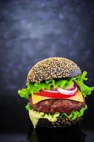 Handmade burger on dark background. Delicious black burger photo