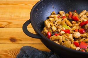 Stir fry chicken, zucchini and pepper in wok photo