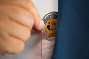 Focus select and blur Foreground Dogecoin DOGE included with Cryptocurrency in suit bag business man or bank employees wearing a blue suit. Filed and put and give to me. photo