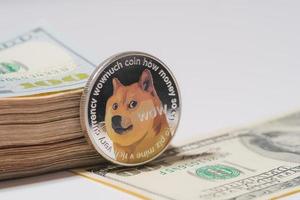 dogecoin doge incluido con moneda de criptomoneda en la pila de dinero de cien dólares estadounidenses tecnología de cadena de bloques dinero futuro primer plano y fondo macro foto